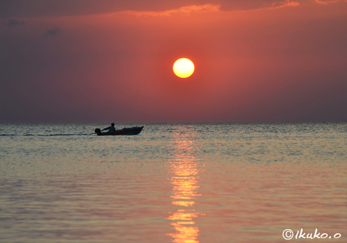 日没前の太陽と漁船