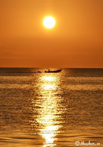 夕陽に輝く海と漁船