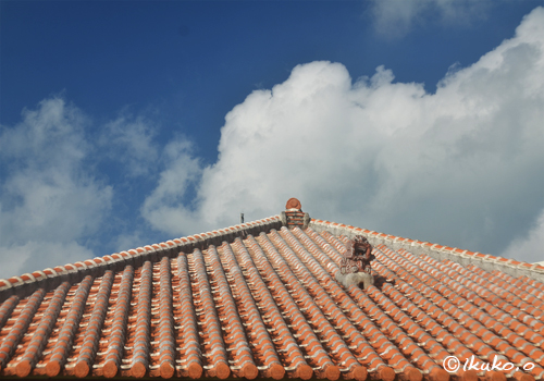屋根の上のシーサーと入道雲