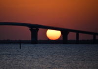 橋桁の間に沈むまん丸な夕陽