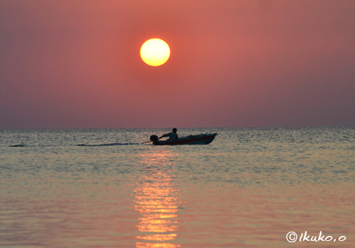 日没前の太陽と漁船